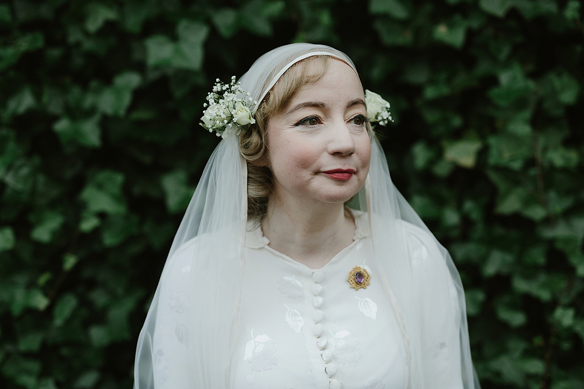 Berenice wore a 1930's vintage wedding dress for her intimate wedding held at home. The couple's ceremony involved a traditional Celtic handfasting. Photography by Rooftop Mosaic.