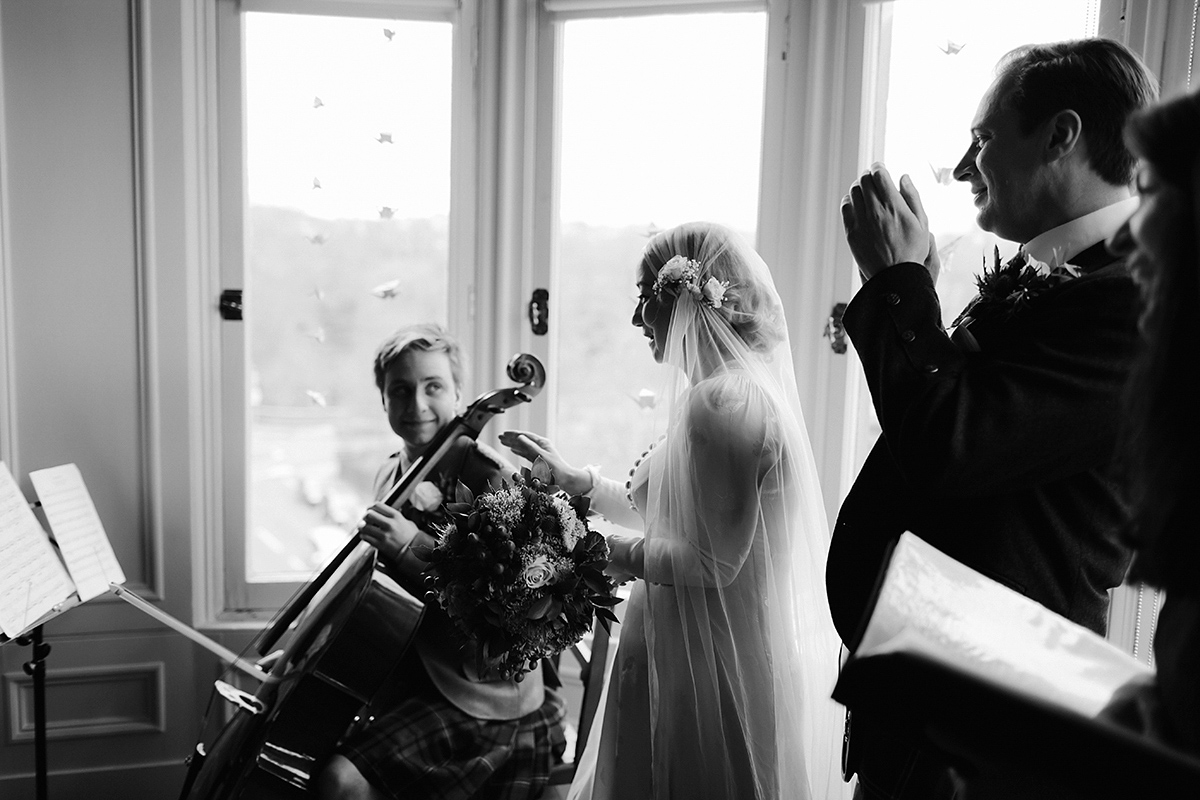 Berenice wore a 1930's vintage wedding dress for her intimate wedding held at home. The couple's ceremony involved a traditional Celtic handfasting. Photography by Rooftop Mosaic.