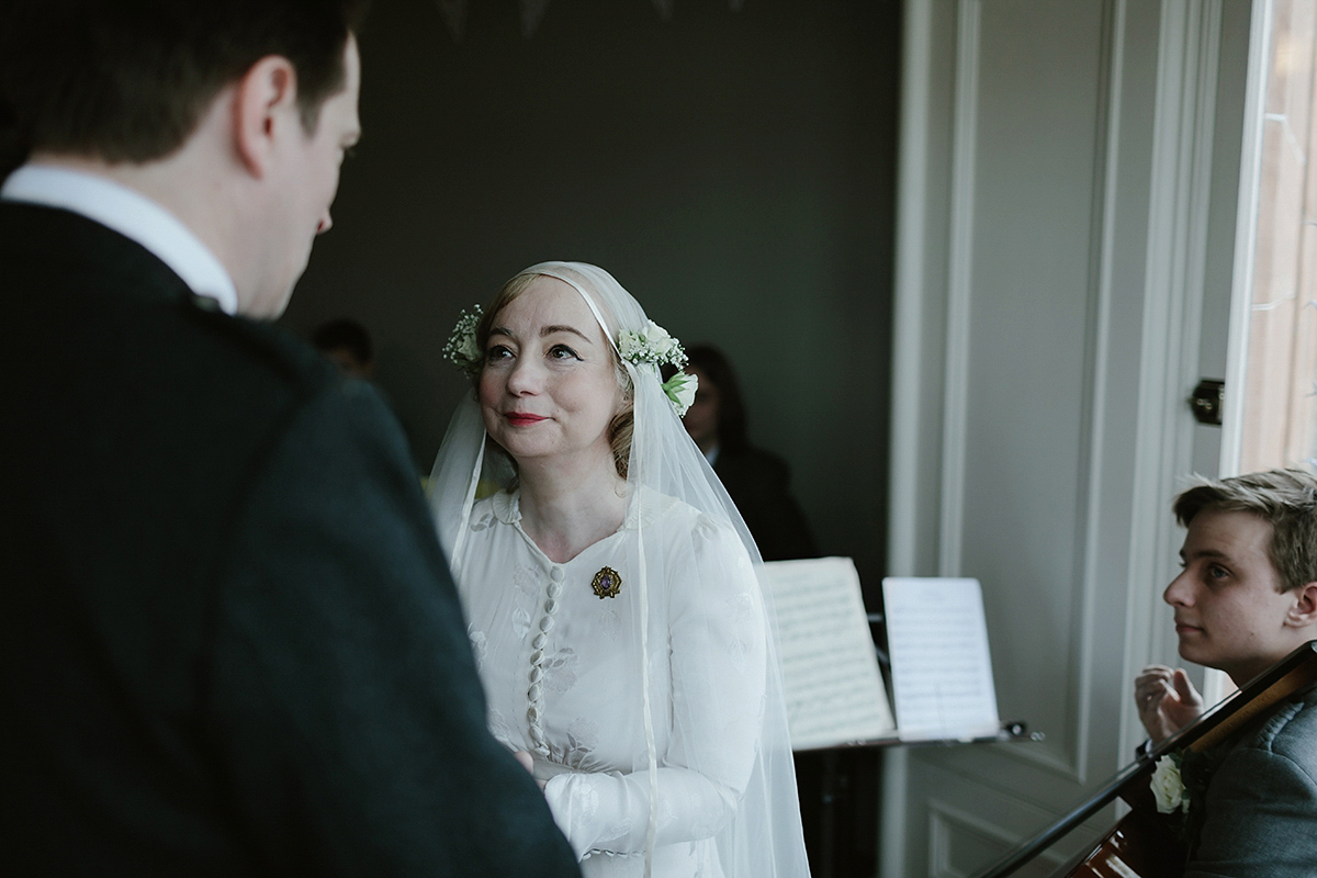 Berenice wore a 1930's vintage wedding dress for her intimate wedding held at home. The couple's ceremony involved a traditional Celtic handfasting. Photography by Rooftop Mosaic.