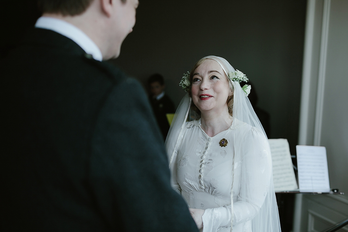 Berenice wore a 1930's vintage wedding dress for her intimate wedding held at home. The couple's ceremony involved a traditional Celtic handfasting. Photography by Rooftop Mosaic.