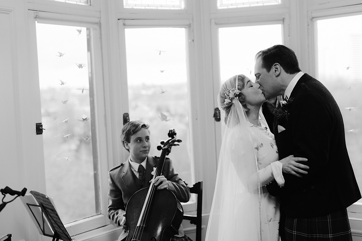 Berenice wore a 1930's vintage wedding dress for her intimate wedding held at home. The couple's ceremony involved a traditional Celtic handfasting. Photography by Rooftop Mosaic.