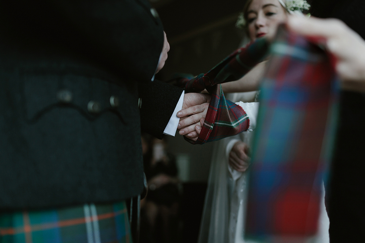 Berenice wore a 1930's vintage wedding dress for her intimate wedding held at home. The couple's ceremony involved a traditional Celtic handfasting. Photography by Rooftop Mosaic.