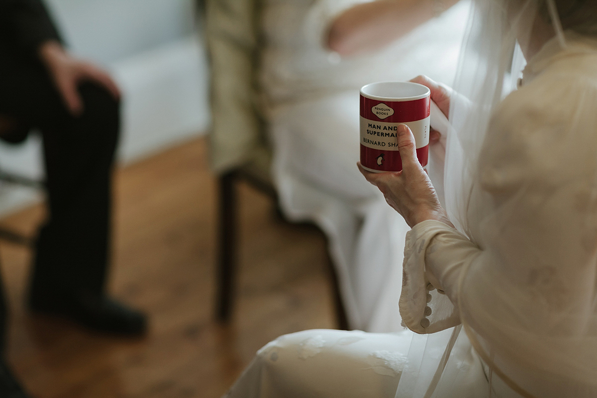 Berenice wore a 1930's vintage wedding dress for her intimate wedding held at home. The couple's ceremony involved a traditional Celtic handfasting. Photography by Rooftop Mosaic.