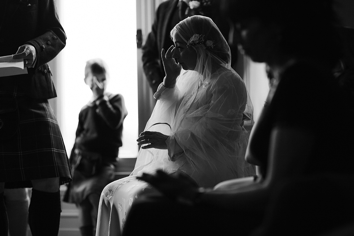 Berenice wore a 1930's vintage wedding dress for her intimate wedding held at home. The couple's ceremony involved a traditional Celtic handfasting. Photography by Rooftop Mosaic.