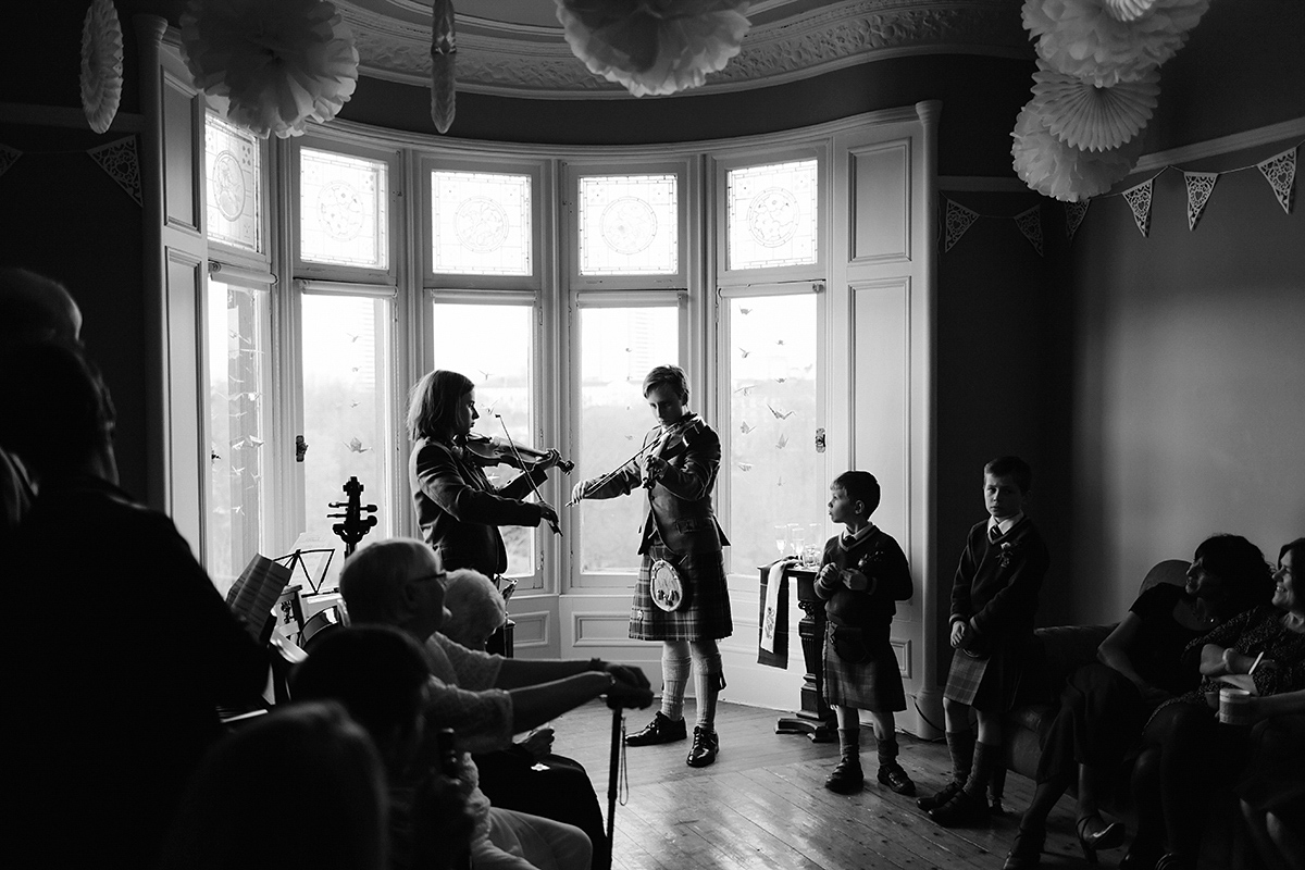 Berenice wore a 1930's vintage wedding dress for her intimate wedding held at home. The couple's ceremony involved a traditional Celtic handfasting. Photography by Rooftop Mosaic.