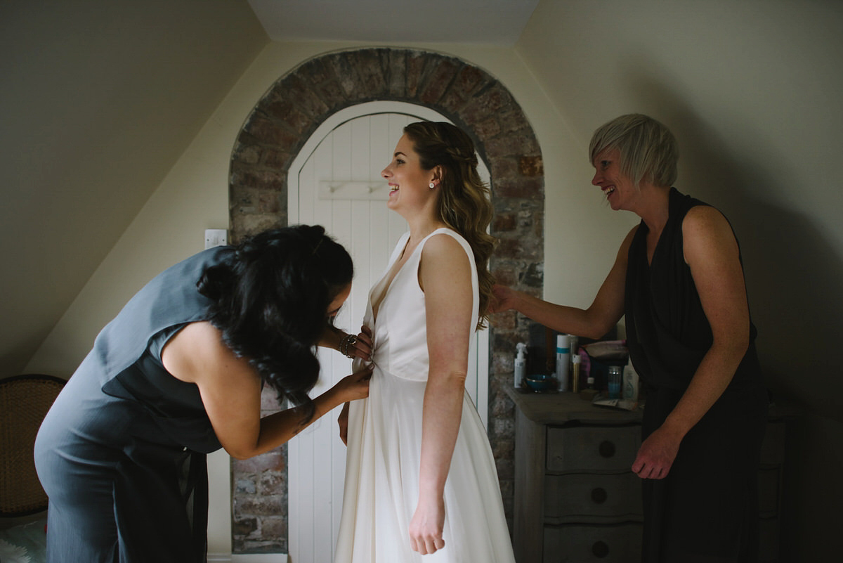 Saskia wore a Halfpenny London gown with feathered sleeves for her nature inspired wedding in Scotland. Photography by Lisa Devine.