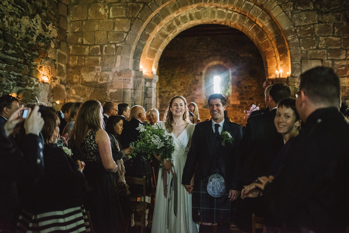 Saskia wore a Halfpenny London gown with feathered sleeves for her nature inspired wedding in Scotland. Photography by Lisa Devine.