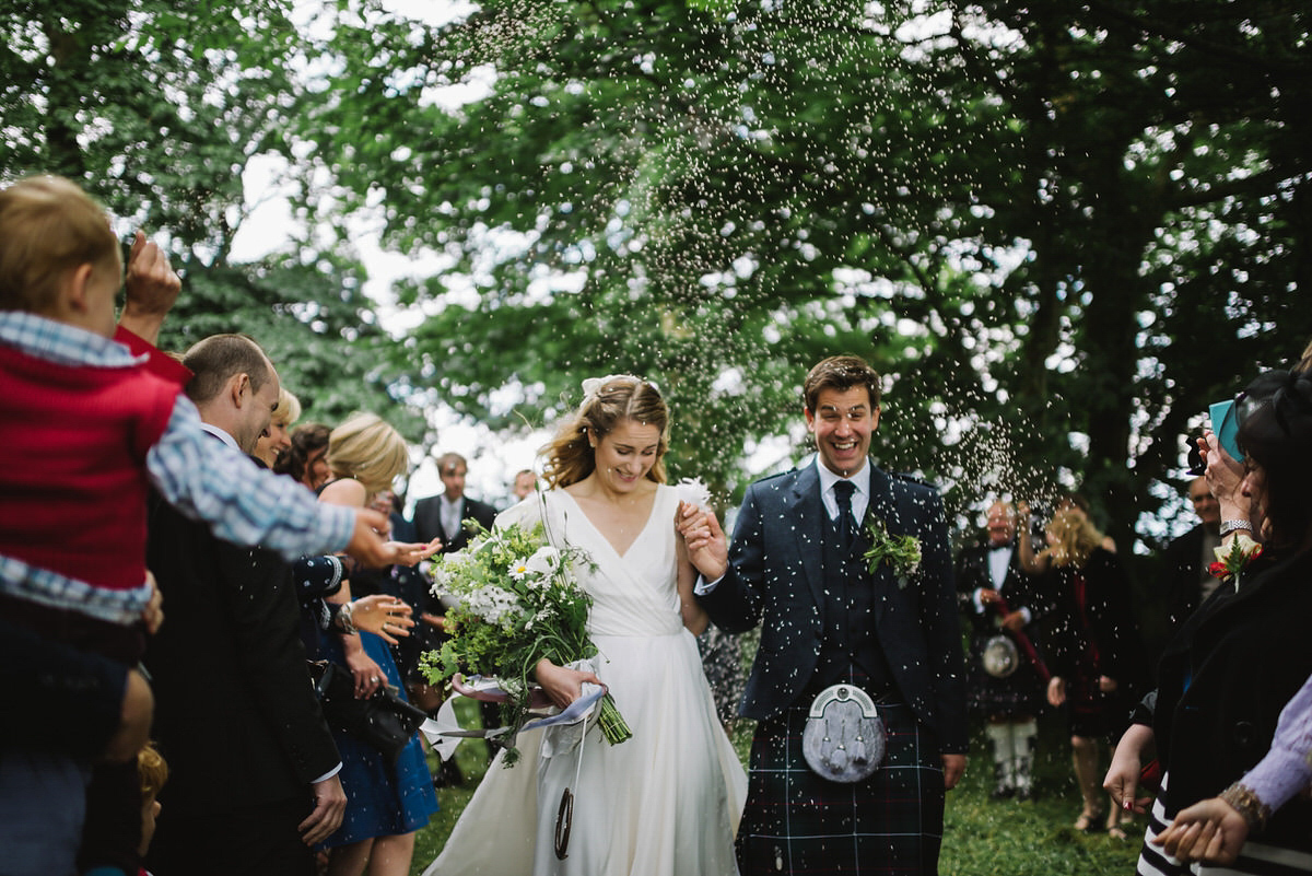 Saskia wore a Halfpenny London gown with feathered sleeves for her nature inspired wedding in Scotland. Photography by Lisa Devine.