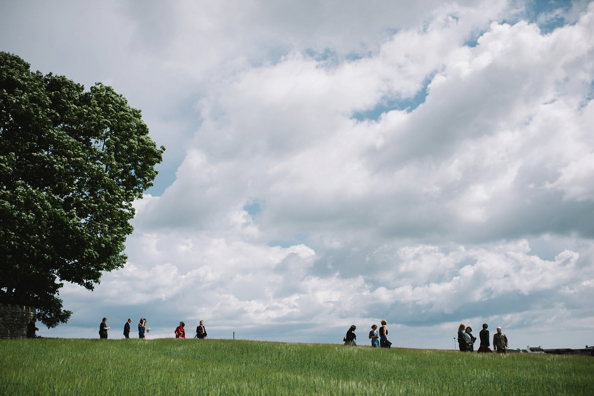 Saskia wore a Halfpenny London gown with feathered sleeves for her nature inspired wedding in Scotland. Photography by Lisa Devine.