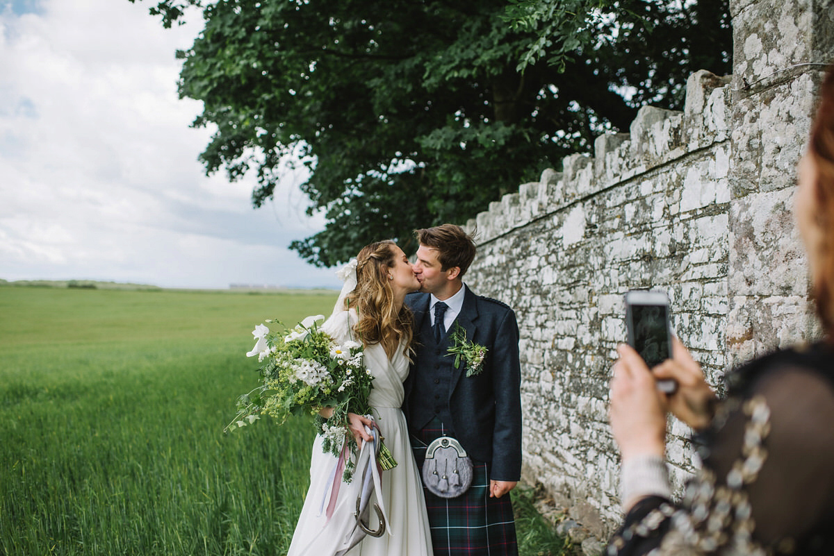 Saskia wore a Halfpenny London gown with feathered sleeves for her nature inspired wedding in Scotland. Photography by Lisa Devine.