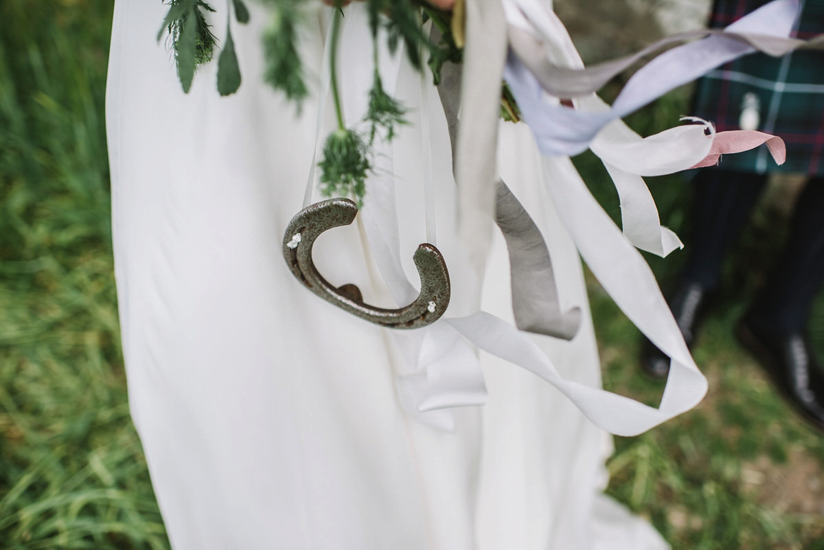 Saskia wore a Halfpenny London gown with feathered sleeves for her nature inspired wedding in Scotland. Photography by Lisa Devine.