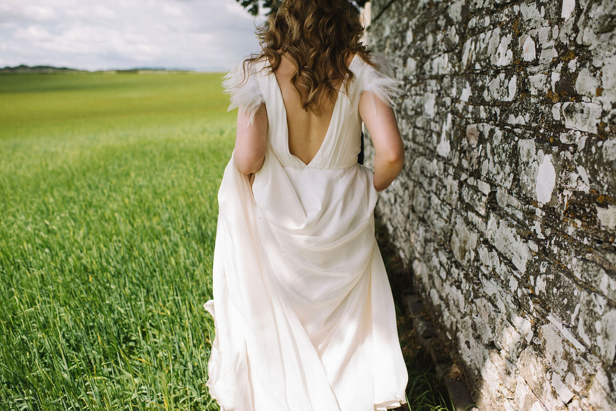 Saskia wore a Halfpenny London gown with feathered sleeves for her nature inspired wedding in Scotland. Photography by Lisa Devine.