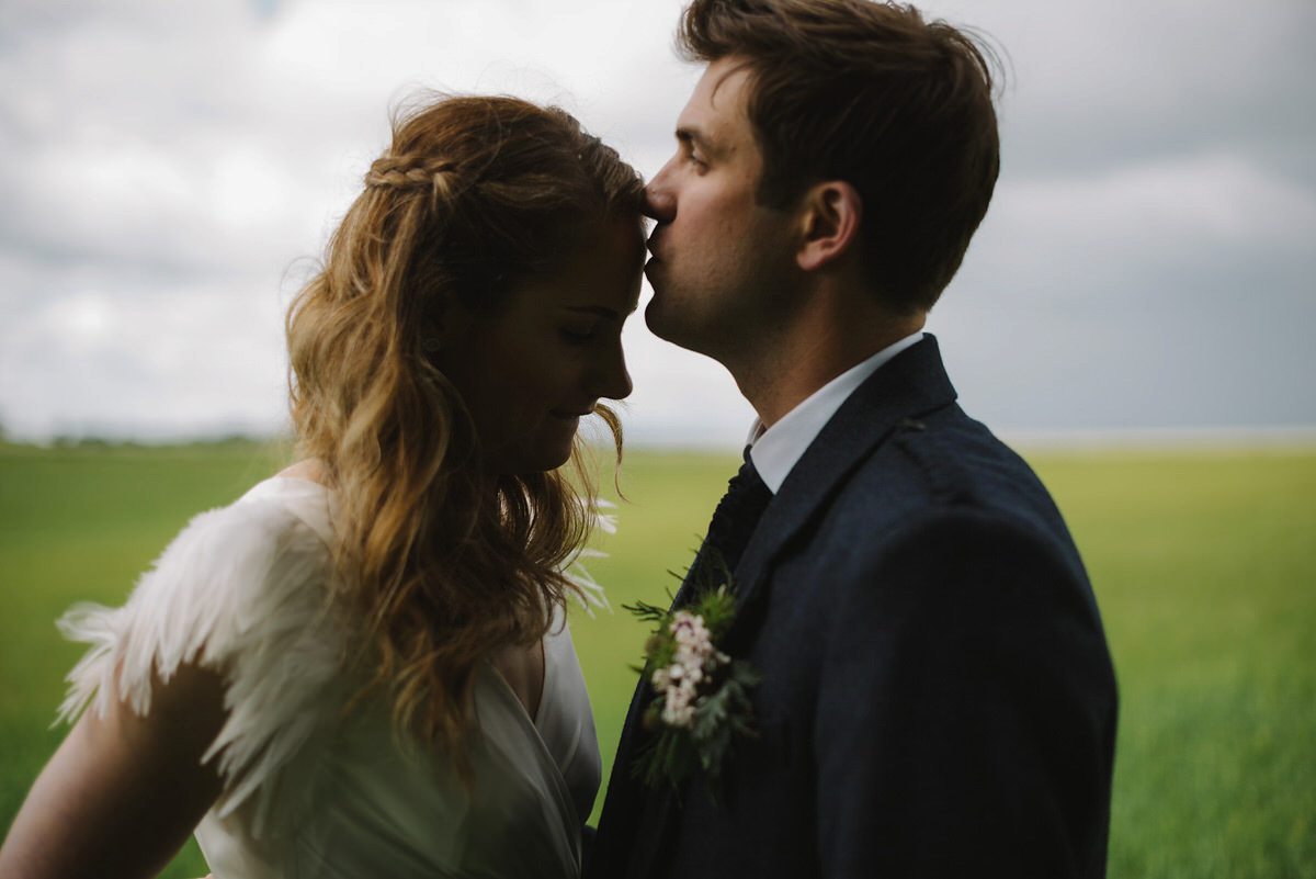 Saskia wore a Halfpenny London gown with feathered sleeves for her nature inspired wedding in Scotland. Photography by Lisa Devine.