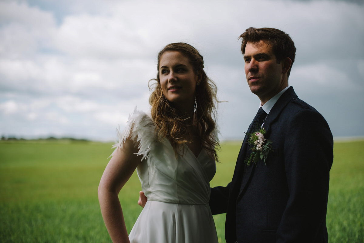 Saskia wore a Halfpenny London gown with feathered sleeves for her nature inspired wedding in Scotland. Photography by Lisa Devine.