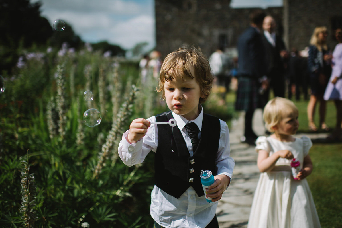 Saskia wore a Halfpenny London gown with feathered sleeves for her nature inspired wedding in Scotland. Photography by Lisa Devine.