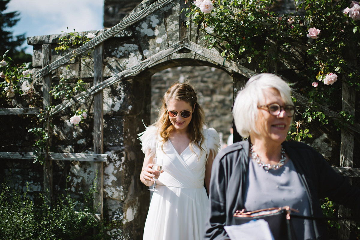 Saskia wore a Halfpenny London gown with feathered sleeves for her nature inspired wedding in Scotland. Photography by Lisa Devine.