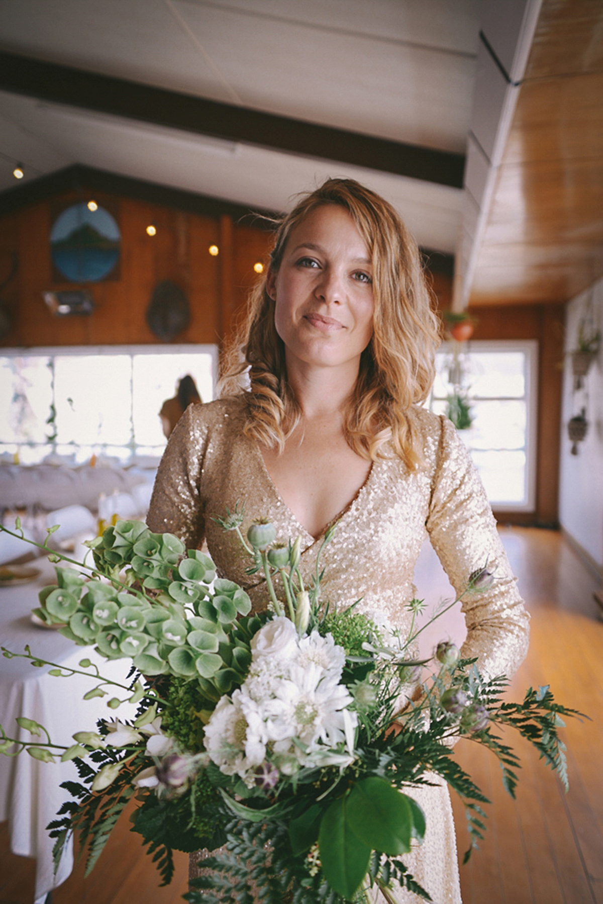 Amelia wore a gold sequin wedding dress for her relaxed, homespun and handmade wedding by the seaside in New Zealand. Photography by Sarah Burton.