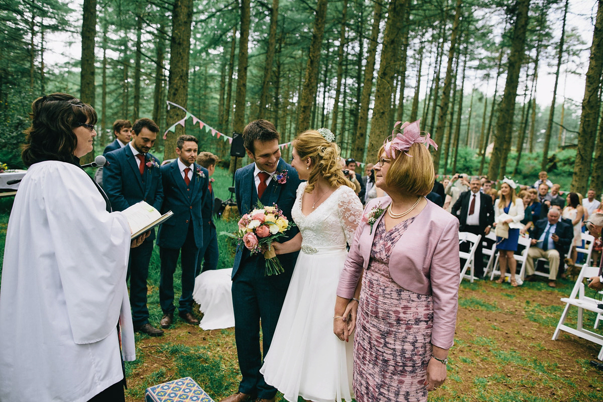 Sarah wore a 1950's inspired tea length wedding dress for her woodland wedding in Scotland. Images captured by Mirrorbox Photography.