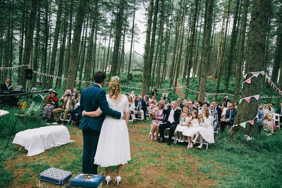 Sarah wore a 1950's inspired tea length wedding dress for her woodland wedding in Scotland. Images captured by Mirrorbox Photography.
