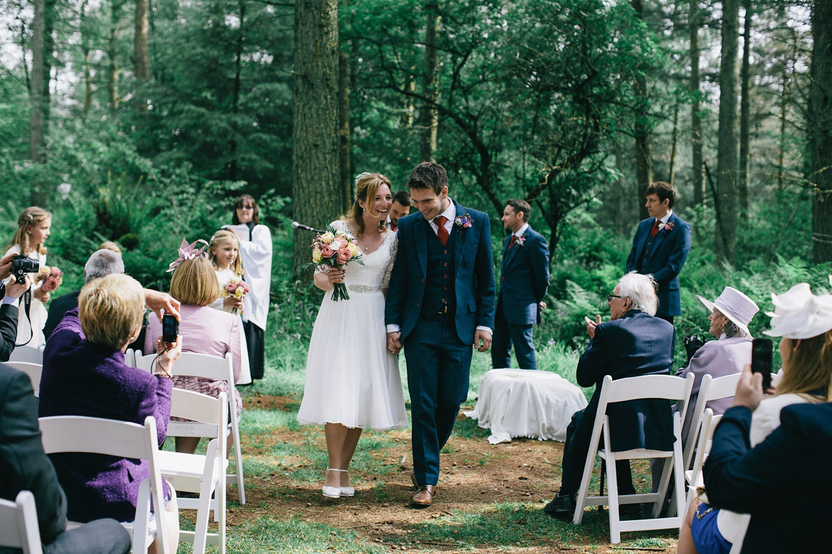 Sarah wore a 1950's inspired tea length wedding dress for her woodland wedding in Scotland. Images captured by Mirrorbox Photography.