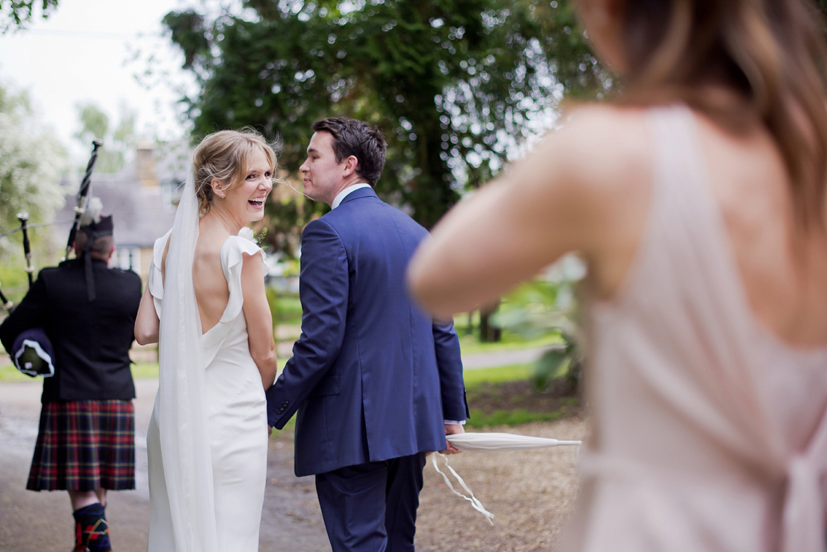 Connie wore a black leather jacket and dress by Belle & Bunty for her English wildfllower meadow inspired wedding. Photography by Emma Sekhonn.