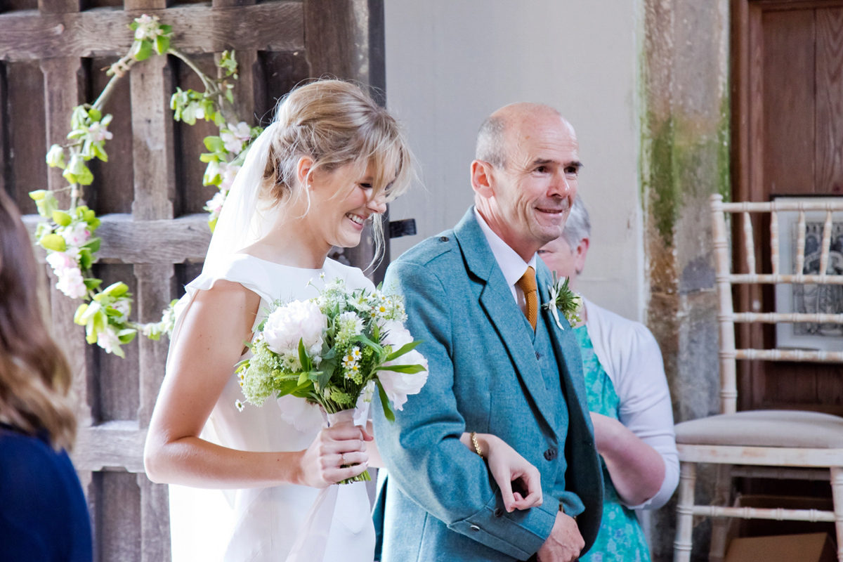 Connie wore a black leather jacket and dress by Belle & Bunty for her English wildfllower meadow inspired wedding. Photography by Emma Sekhonn.