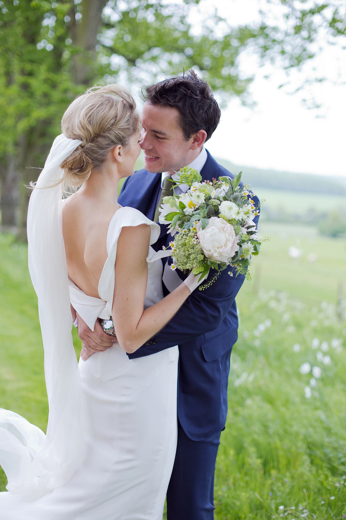 Connie wore a black leather jacket and dress by Belle & Bunty for her English wildfllower meadow inspired wedding. Photography by Emma Sekhonn.