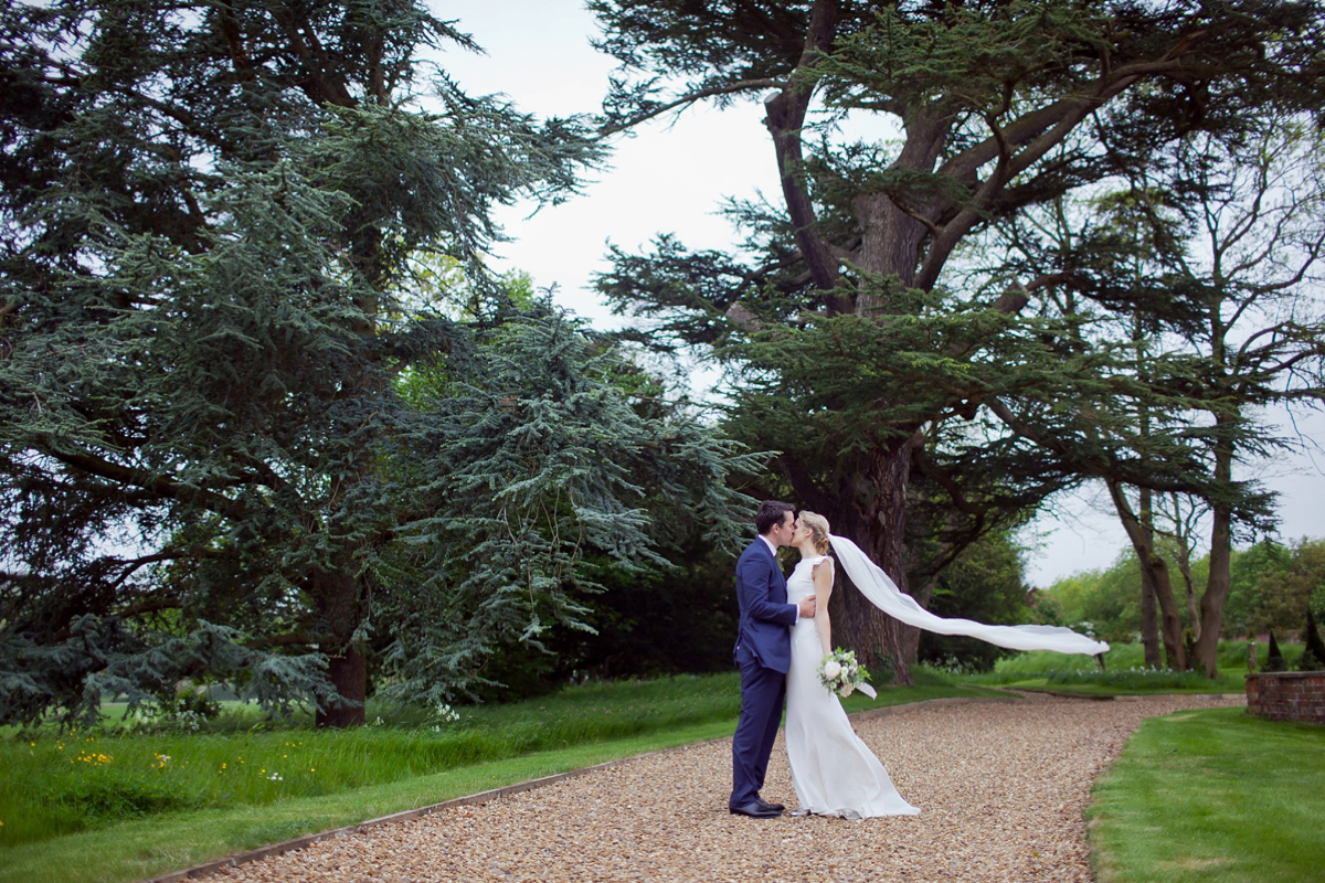 Connie wore a black leather jacket and dress by Belle & Bunty for her English wildfllower meadow inspired wedding. Photography by Emma Sekhonn.