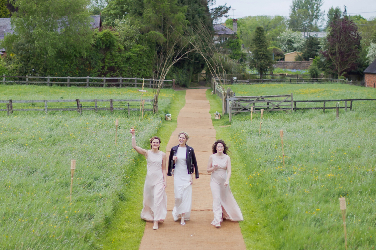 Connie wore a black leather jacket and dress by Belle & Bunty for her English wildfllower meadow inspired wedding. Photography by Emma Sekhonn.