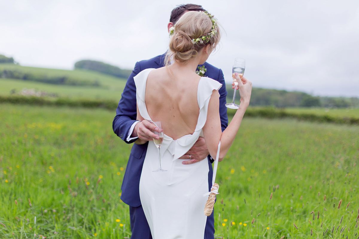 Connie wore a black leather jacket and dress by Belle & Bunty for her English wildfllower meadow inspired wedding. Photography by Emma Sekhonn.