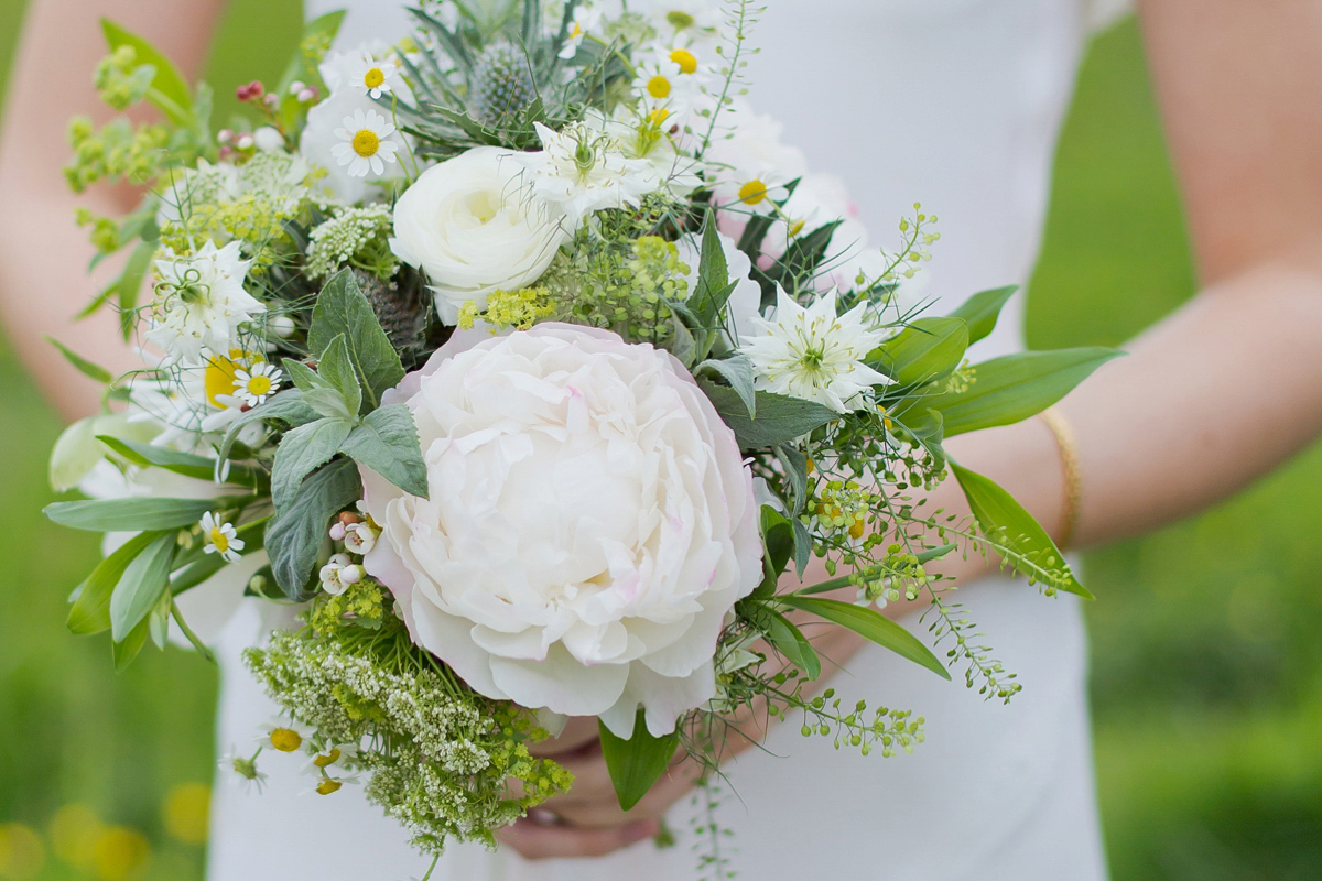 Connie wore a black leather jacket and dress by Belle & Bunty for her English wildfllower meadow inspired wedding. Photography by Emma Sekhonn.