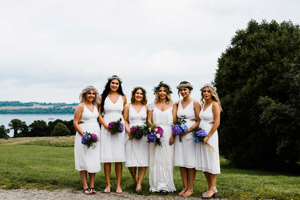 Kirsty wore a Rue de Seine gown from Leonie C. Bridal boutique in Brighton. Her handmade, Summer wedding took place in a Game of Thrones venue in Downpatrick. It was filled with floral chandeliers. Photography by Honey and the Moon.