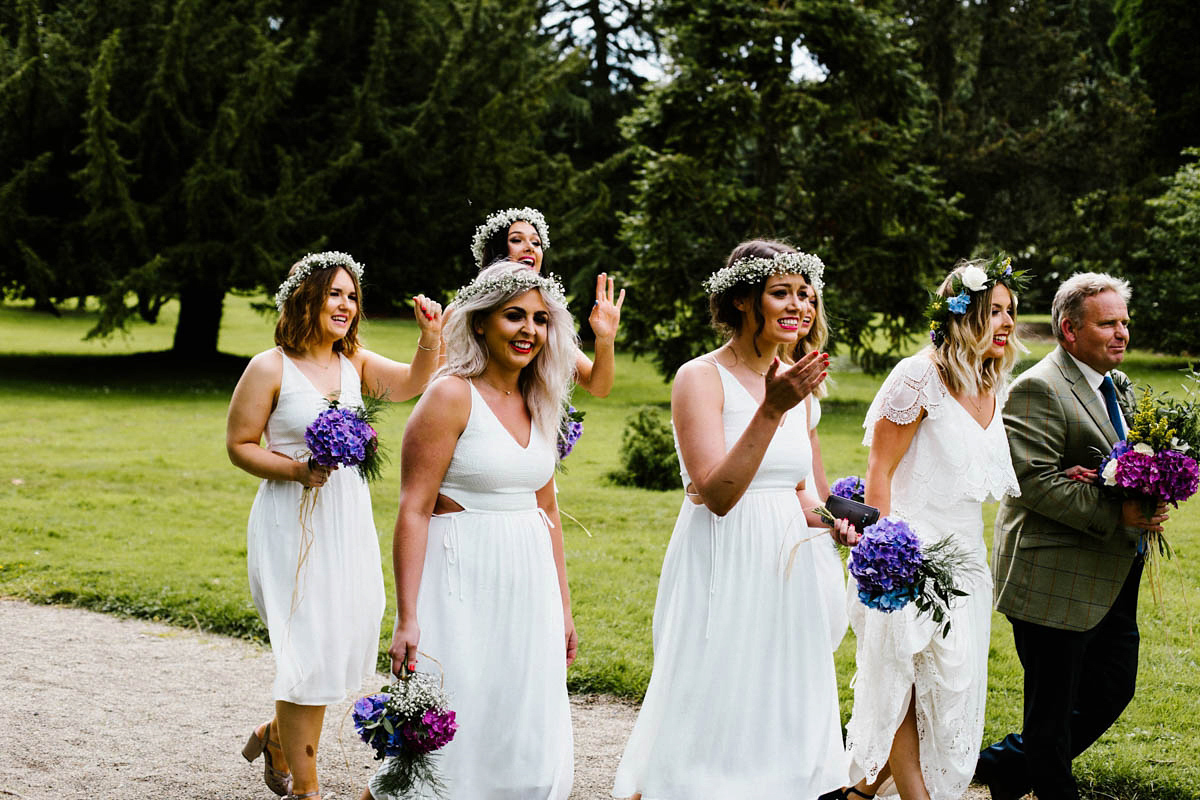 Kirsty wore a Rue de Seine gown from Leonie C. Bridal boutique in Brighton. Her handmade, Summer wedding took place in a Game of Thrones venue in Downpatrick. It was filled with floral chandeliers. Photography by Honey and the Moon.