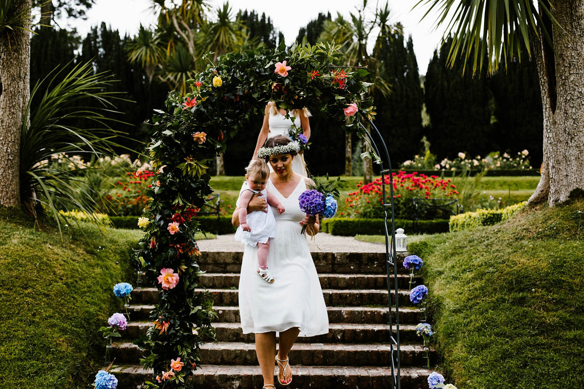 Kirsty wore a Rue de Seine gown from Leonie C. Bridal boutique in Brighton. Her handmade, Summer wedding took place in a Game of Thrones venue in Downpatrick. It was filled with floral chandeliers. Photography by Honey and the Moon.