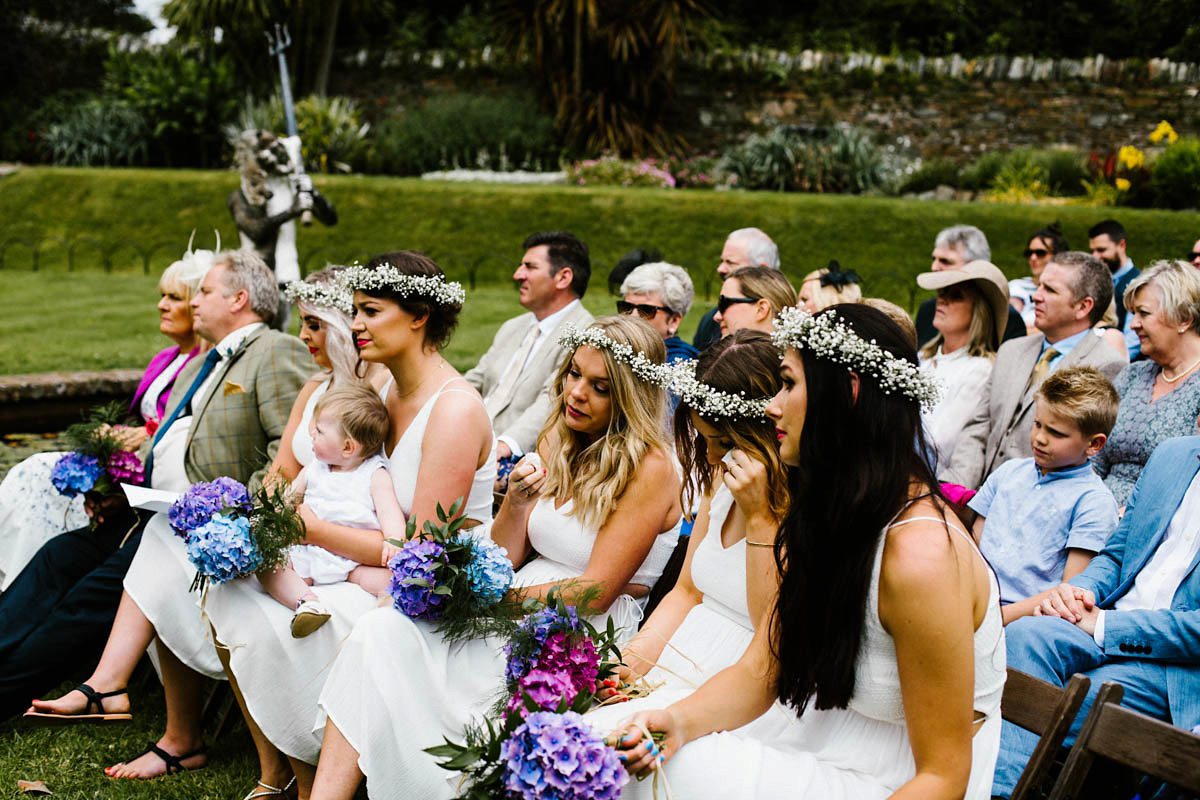 Kirsty wore a Rue de Seine gown from Leonie C. Bridal boutique in Brighton. Her handmade, Summer wedding took place in a Game of Thrones venue in Downpatrick. It was filled with floral chandeliers. Photography by Honey and the Moon.