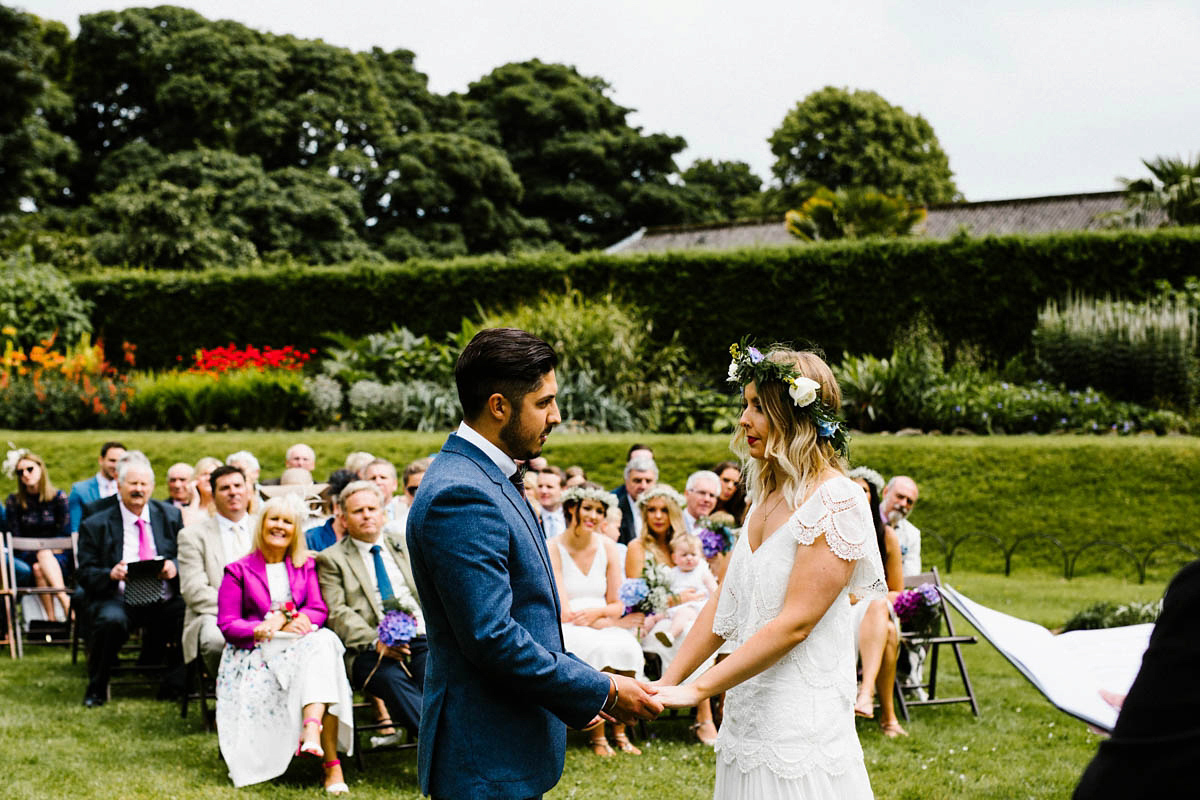 Kirsty wore a Rue de Seine gown from Leonie C. Bridal boutique in Brighton. Her handmade, Summer wedding took place in a Game of Thrones venue in Downpatrick. It was filled with floral chandeliers. Photography by Honey and the Moon.