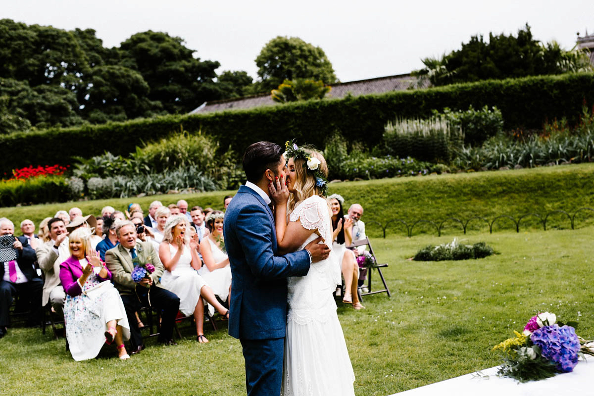 Kirsty wore a Rue de Seine gown from Leonie C. Bridal boutique in Brighton. Her handmade, Summer wedding took place in a Game of Thrones venue in Downpatrick. It was filled with floral chandeliers. Photography by Honey and the Moon.