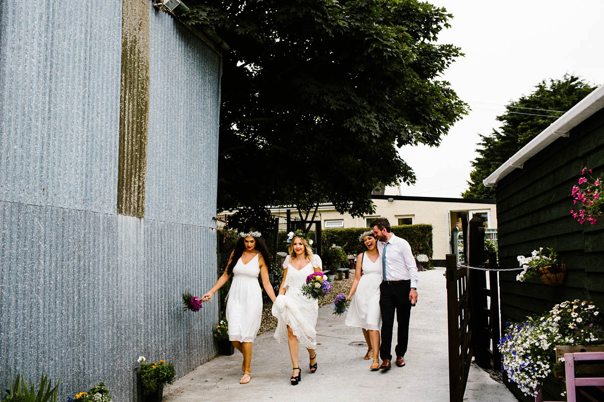 Kirsty wore a Rue de Seine gown from Leonie C. Bridal boutique in Brighton. Her handmade, Summer wedding took place in a Game of Thrones venue in Downpatrick. It was filled with floral chandeliers. Photography by Honey and the Moon.