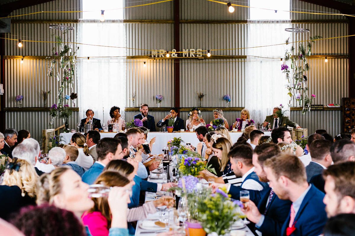 Kirsty wore a Rue de Seine gown from Leonie C. Bridal boutique in Brighton. Her handmade, Summer wedding took place in a Game of Thrones venue in Downpatrick. It was filled with floral chandeliers. Photography by Honey and the Moon.