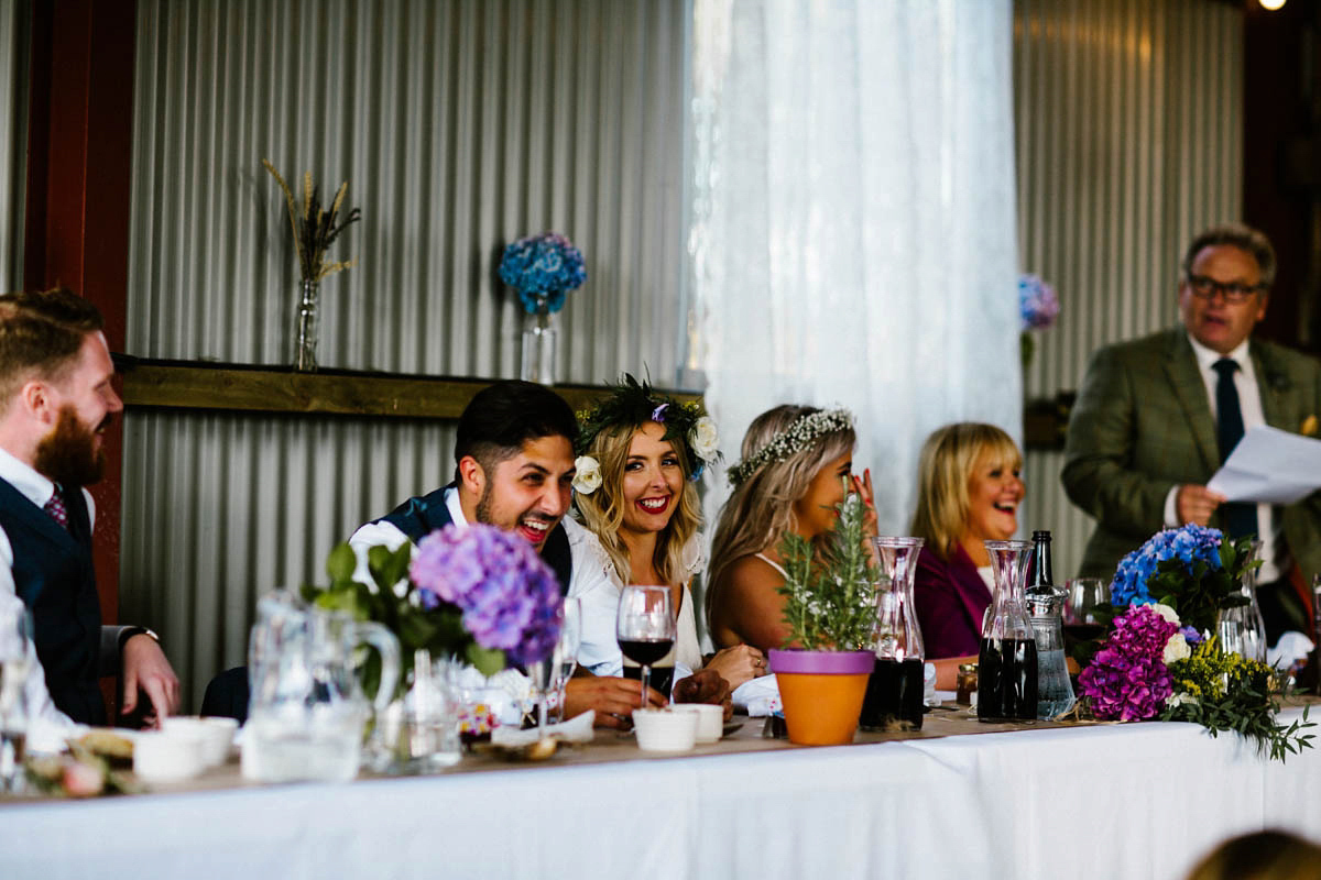 Kirsty wore a Rue de Seine gown from Leonie C. Bridal boutique in Brighton. Her handmade, Summer wedding took place in a Game of Thrones venue in Downpatrick. It was filled with floral chandeliers. Photography by Honey and the Moon.