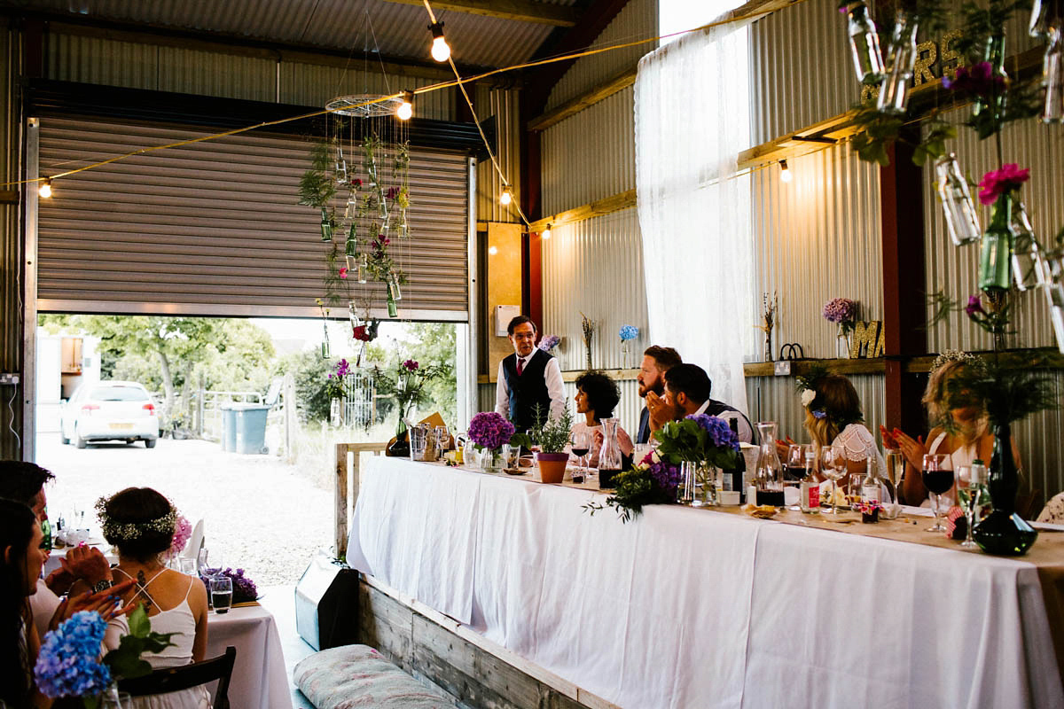 Kirsty wore a Rue de Seine gown from Leonie C. Bridal boutique in Brighton. Her handmade, Summer wedding took place in a Game of Thrones venue in Downpatrick. It was filled with floral chandeliers. Photography by Honey and the Moon.