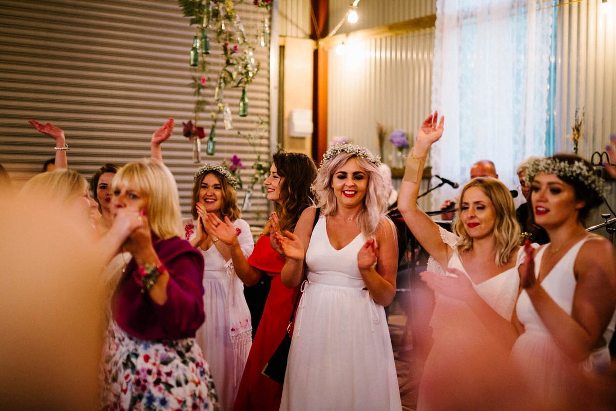 Kirsty wore a Rue de Seine gown from Leonie C. Bridal boutique in Brighton. Her handmade, Summer wedding took place in a Game of Thrones venue in Downpatrick. It was filled with floral chandeliers. Photography by Honey and the Moon.