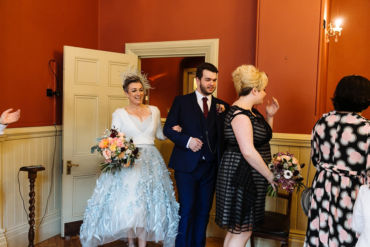 Emma and Marshy had a secret wedding in Brighton. Emma wore a bespoke blue dress by Suzanne Neville. Photography by Nick Tucker.