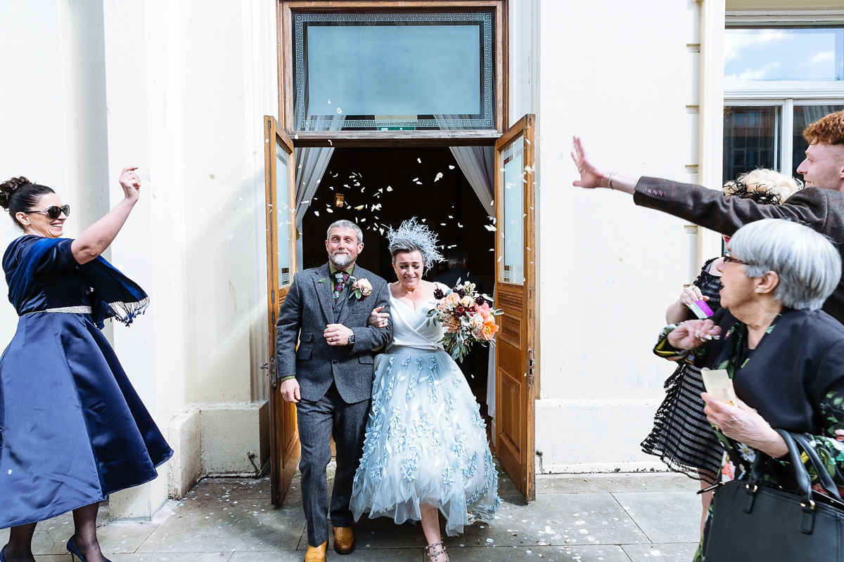 Emma and Marshy had a secret wedding in Brighton. Emma wore a bespoke blue dress by Suzanne Neville. Photography by Nick Tucker.