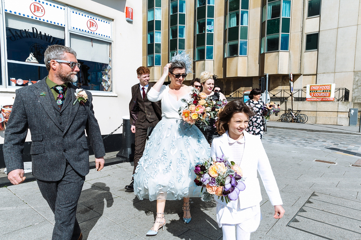 Emma and Marshy had a secret wedding in Brighton. Emma wore a bespoke blue dress by Suzanne Neville. Photography by Nick Tucker.