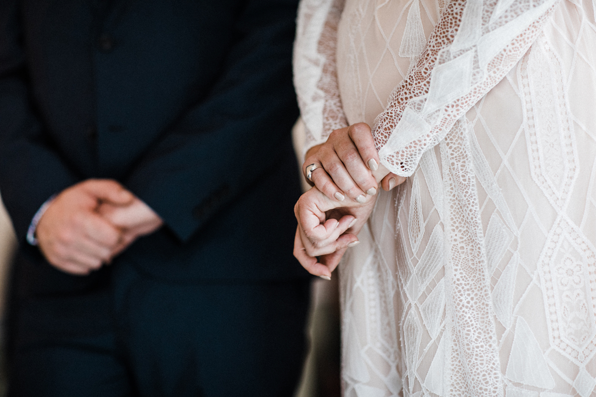 14 Close up of bride and grooms hand during the ceremony