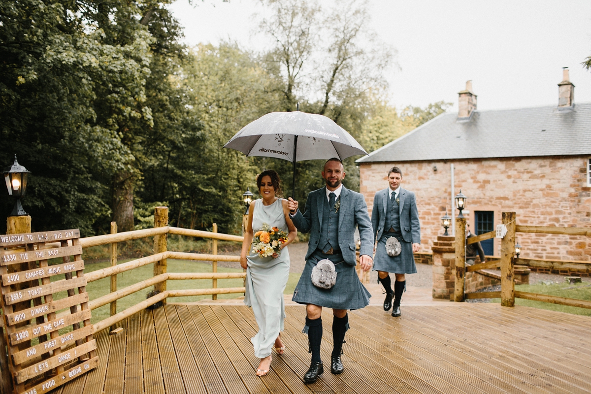 15 Bridesmaid under an umbrella wearing pale green Ghost dress