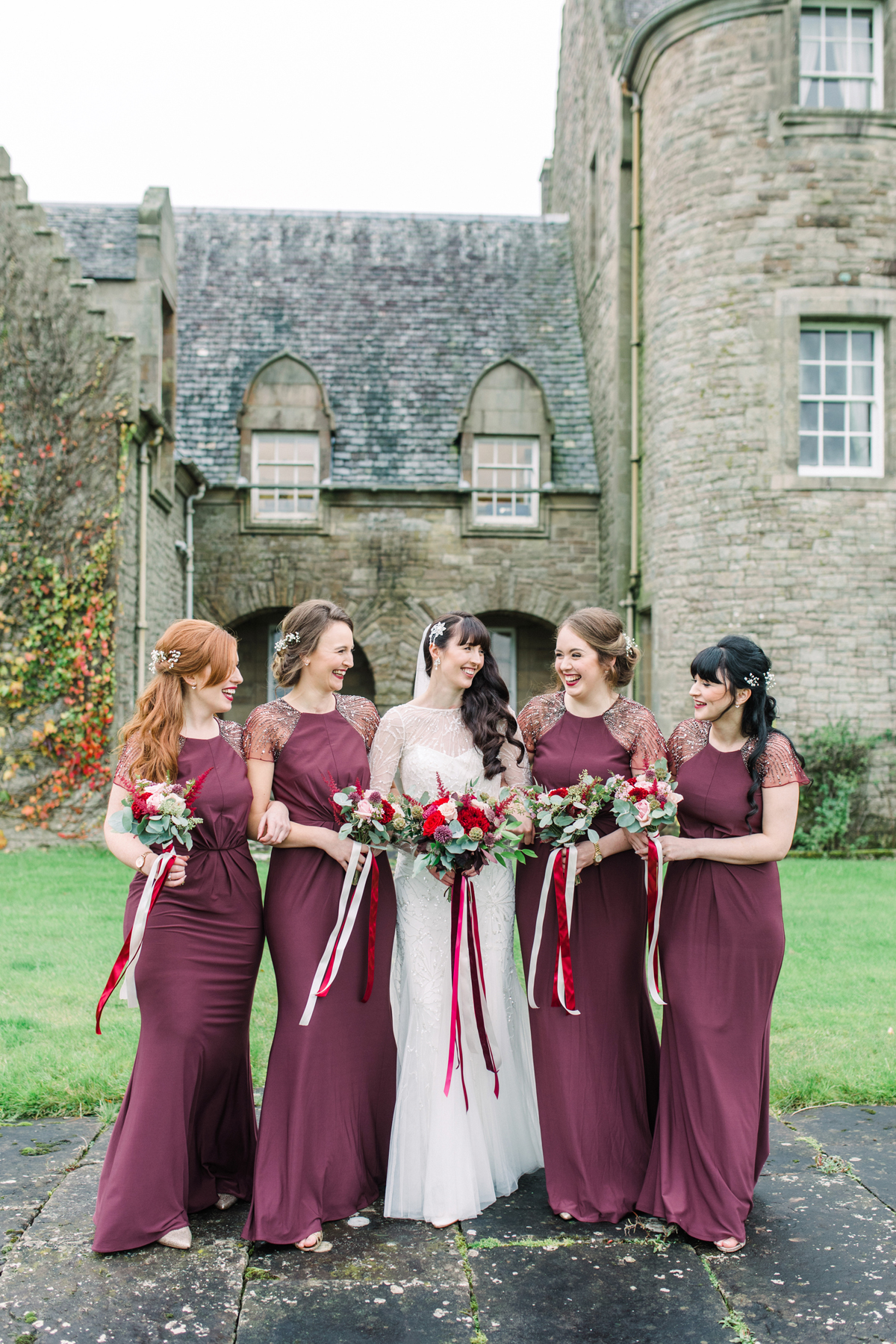 21 Bridesmaids wearing floorlength Biba dresses in burgundy