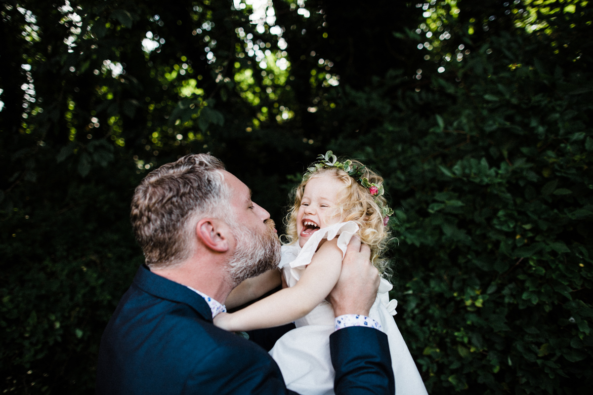 21 Flowergirl laughing as she is kissed by the groom