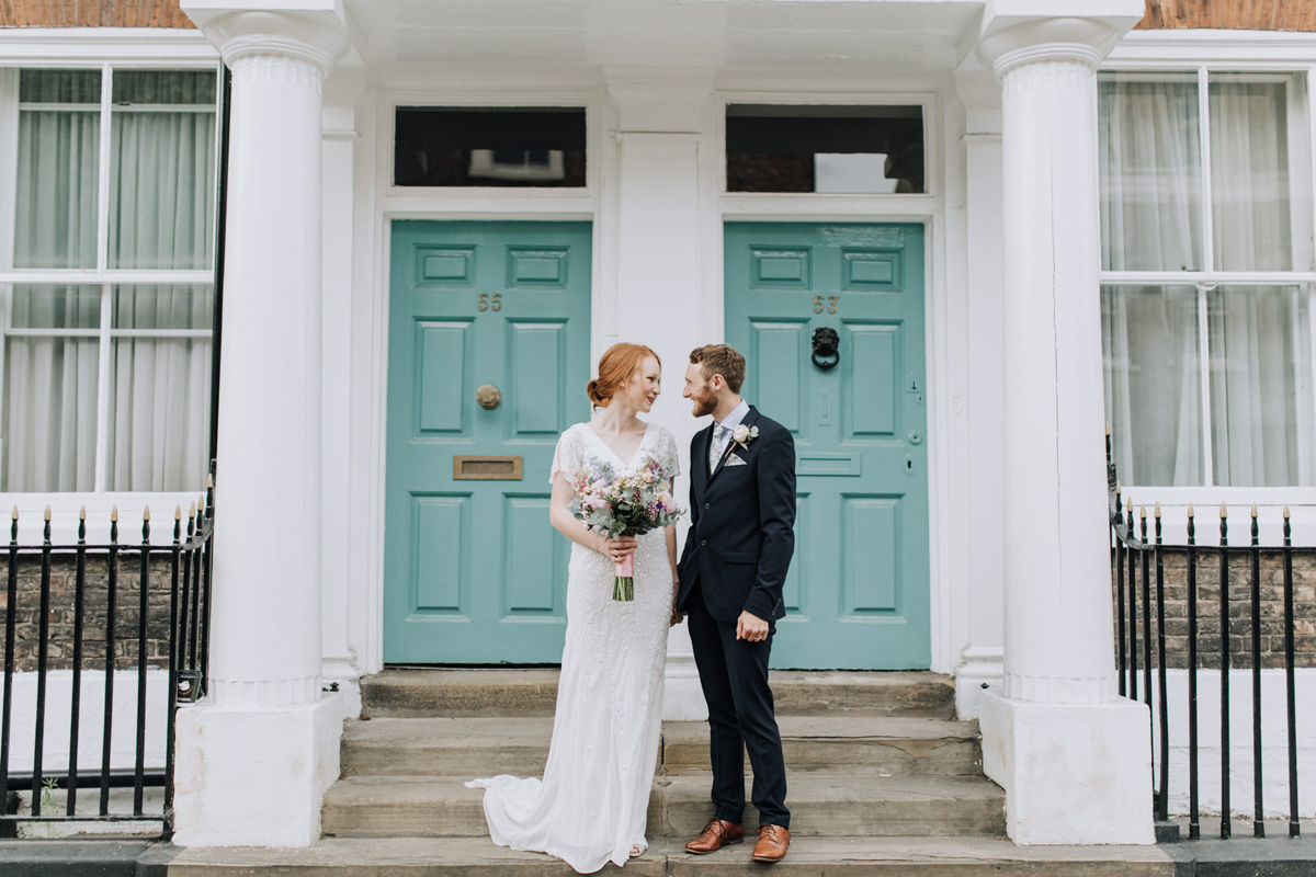 30 Bride and groom justmarried and standout outside a green door